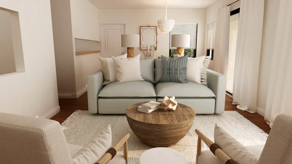 Airy living room with a white sofa, a round wood coffee table, and soft neutral pillows