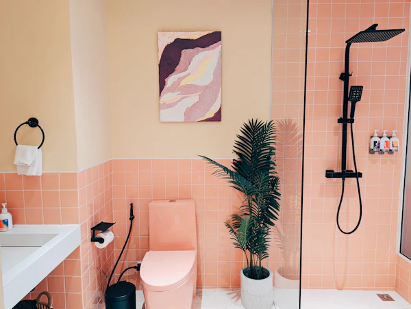 Bathroom with terracotta-pink tile, a rain shower, and a potted palm