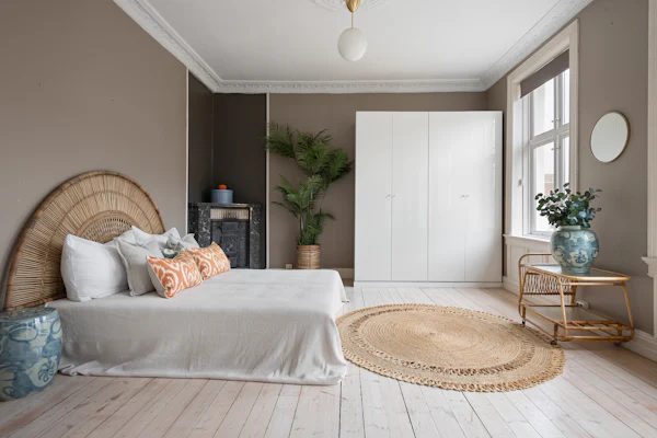 Bedroom with a full bed, a woven rattan headboard, and pale wood floors
