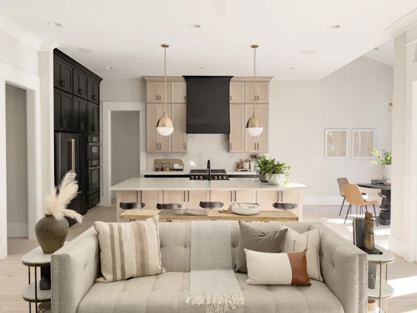 Bright open living room with a sectional sofa and an open kitchen behind it